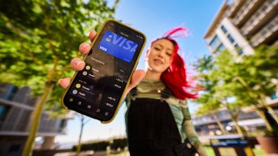 Gen Z adult showing a smartphone displaying a Visa card and transactions