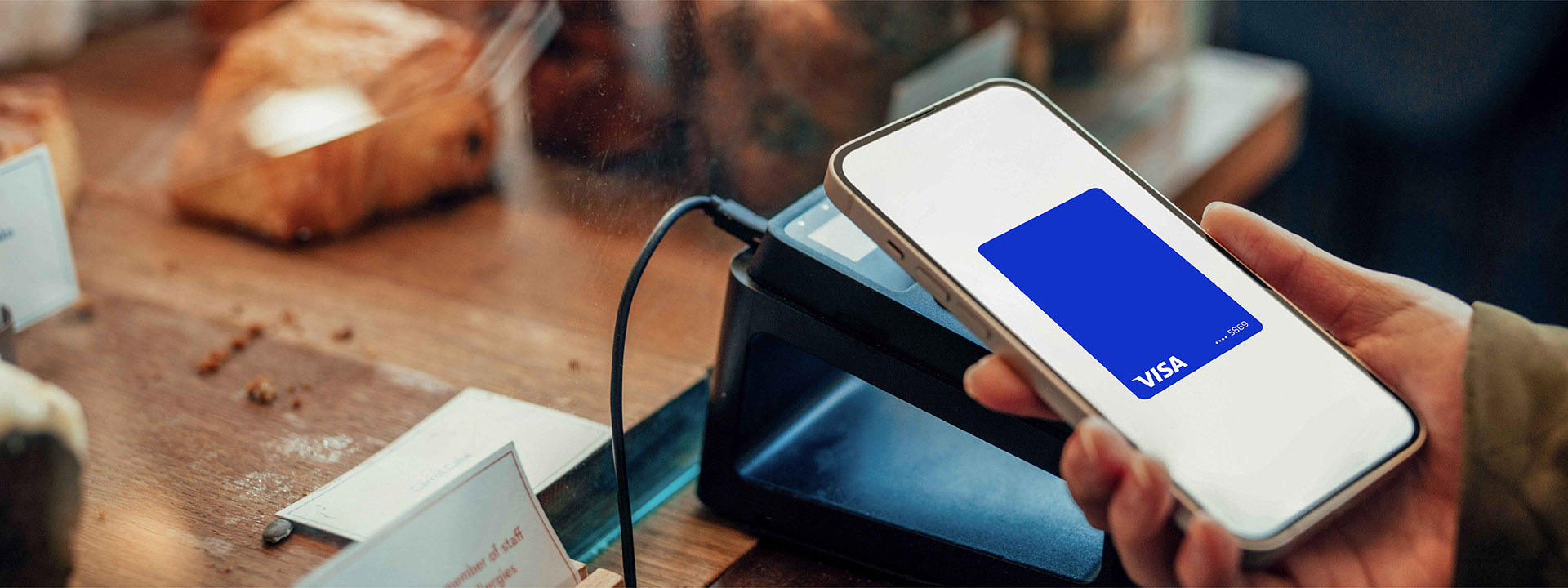 Mobile phone making a card payment at POS in cafe