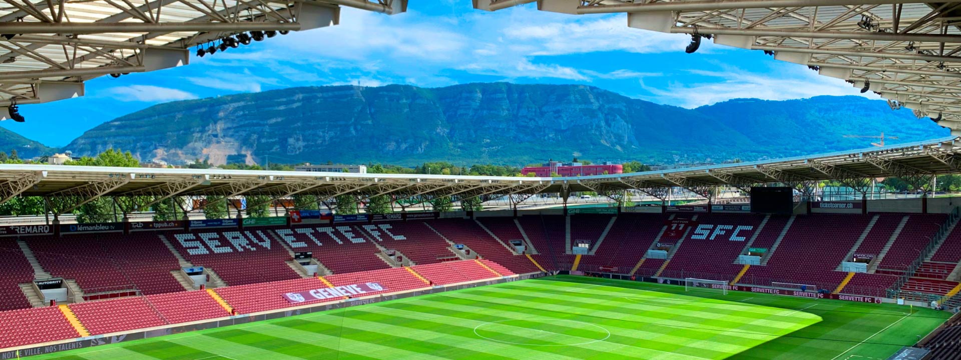 Open top football stadium with mountains in the background