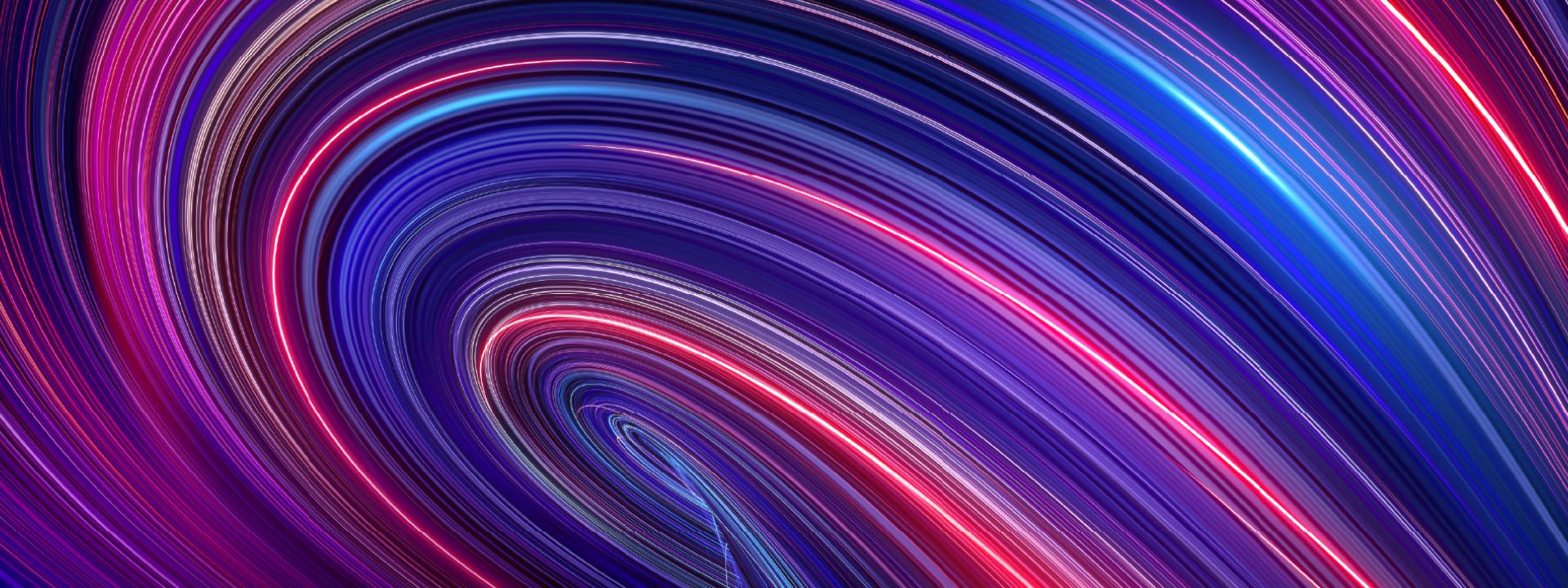 Abstract image of swirling light trails in shades of purple, blue, and pink. 