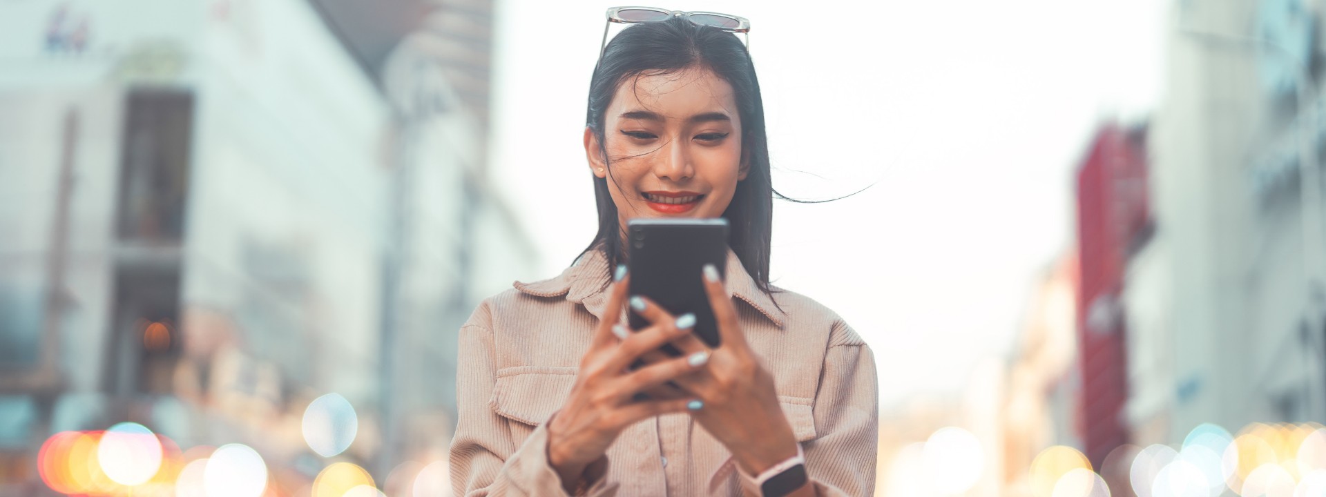 woman looking at mobile while walking in the street