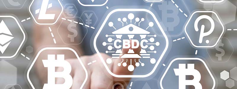 Hand pointing at glass displaying a web of crypto symbols connected by dotted lines, including Bitcoin, CBDC, Polkadot, dollar, yen, and euro signs.