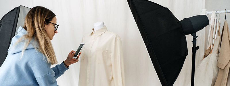 Photographer taking a picture of a shirt for a recommerce shopping website.