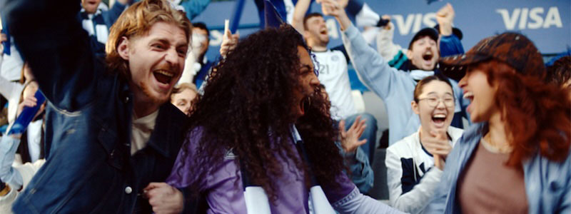 Crowd cheering in a stadium during a sporting event, people clapping and shouting with excitement