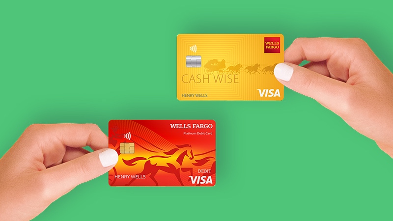 On a green background, a hand on the left holding a Wells Fargo Visa debit card and a hand on the right holding a Wells Fargo Visa credit card.