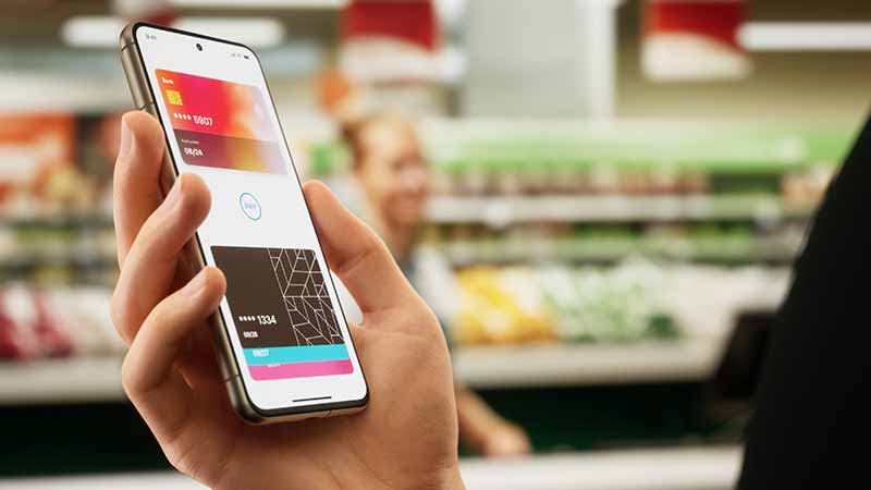 Close up of a person looking at their digital wallet on their mobile phone in the grocery store.