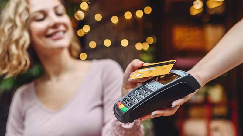 A woman tapping her card to pay.