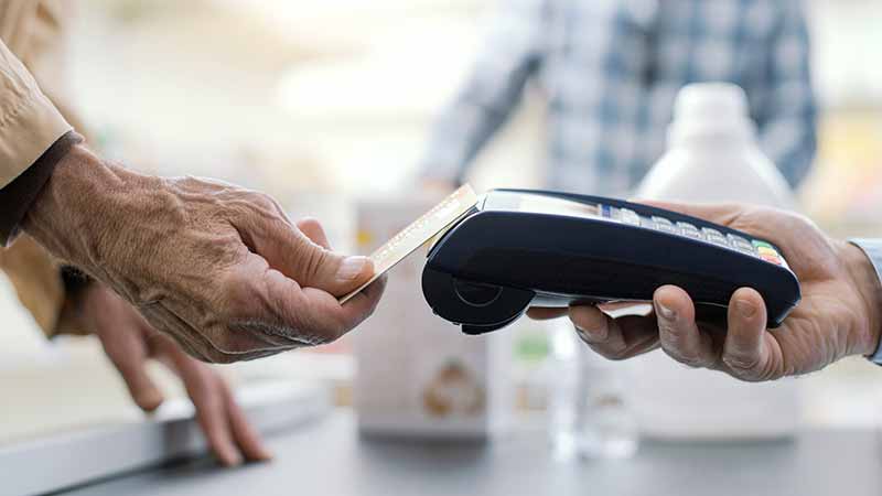 Close up of a person taping their card to pay.