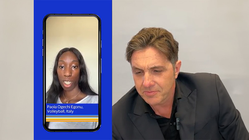 A man wearing a mic engaged in a phone conversation with Italian volleyball player Paola Ogechi Egonu