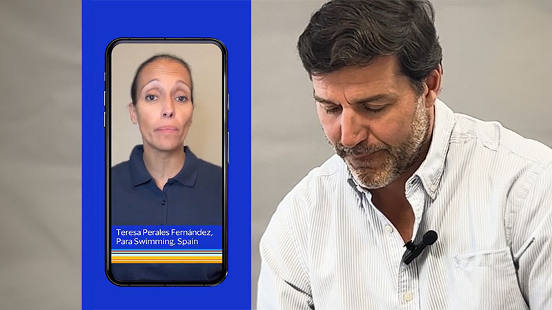 A man glancing down engaged in a phone conversation with Spanish paralympic swimmer Teresa Perales Fernández