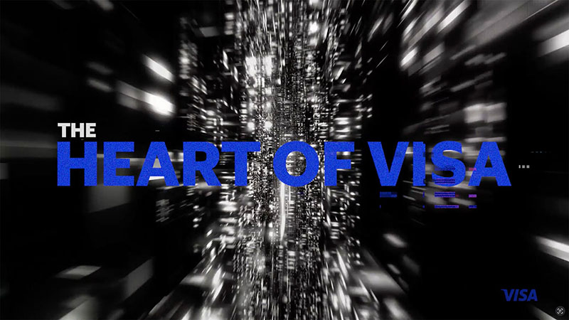 The Heart of Visa title and Visa logo over blurry, static-filled black-and-white video background.
